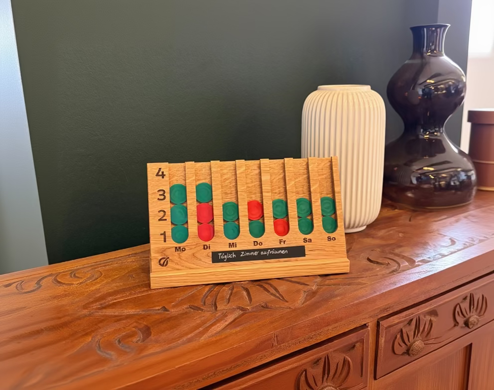 GoalBalance Habit Tracker Holz auf Holzkommode mit Beschriftung Täglich Zimmer aufräumen – Wohnzimmer Lifestyle